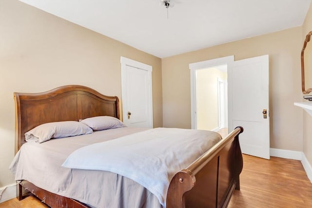 bedroom with light wood-style flooring and baseboards