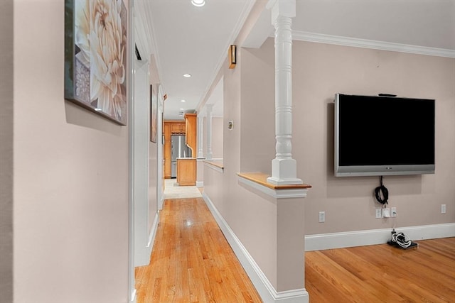 corridor featuring light wood-style floors, baseboards, ornamental molding, and recessed lighting