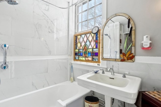 bathroom featuring tiled shower / bath and tile walls