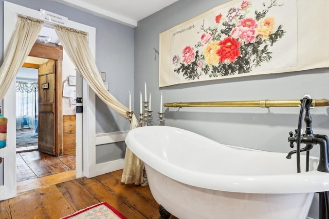 bathroom featuring wood-type flooring and a tub