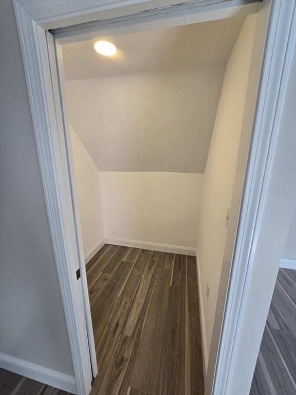 bonus room featuring baseboards, vaulted ceiling, and dark wood-type flooring