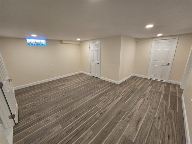 below grade area with baseboards, dark wood-type flooring, and recessed lighting