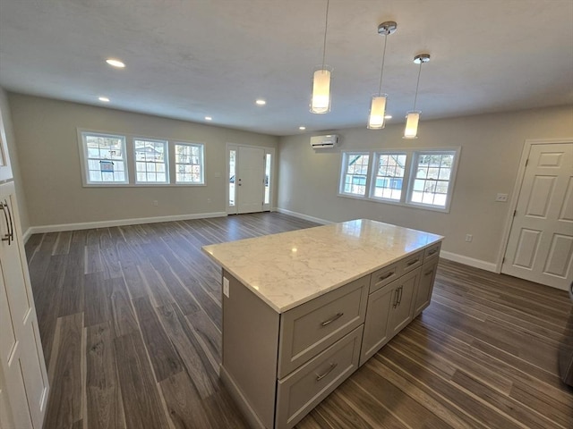 kitchen featuring gray cabinetry, a kitchen island, dark wood finished floors, and a wall mounted air conditioner