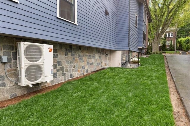 197-199 Winchester St, Brookline, MA 02446 - view of side of property with stone siding, a cooling unit, and a yard