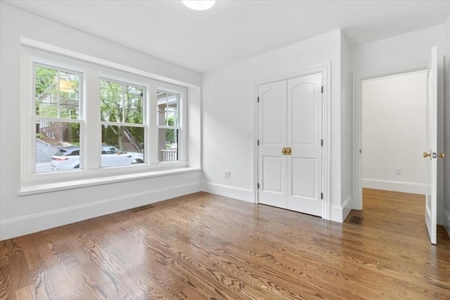 197-199 Winchester St, Brookline, MA 02446 - unfurnished bedroom with baseboards, wood finished floors, and a closet