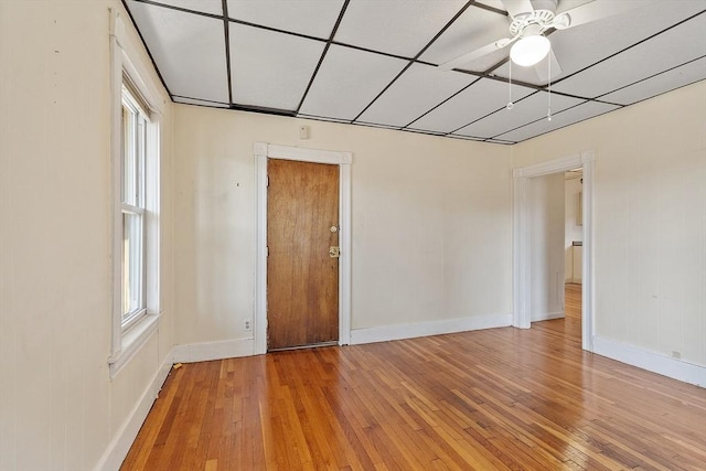 spare room with hardwood / wood-style floors, a drop ceiling, and ceiling fan