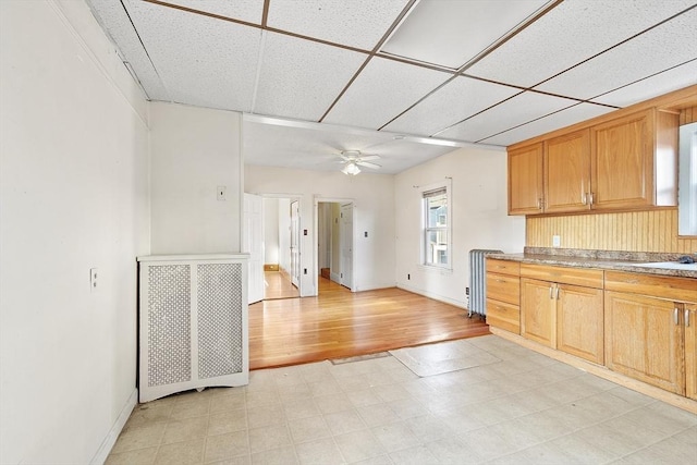 kitchen featuring ceiling fan and a drop ceiling