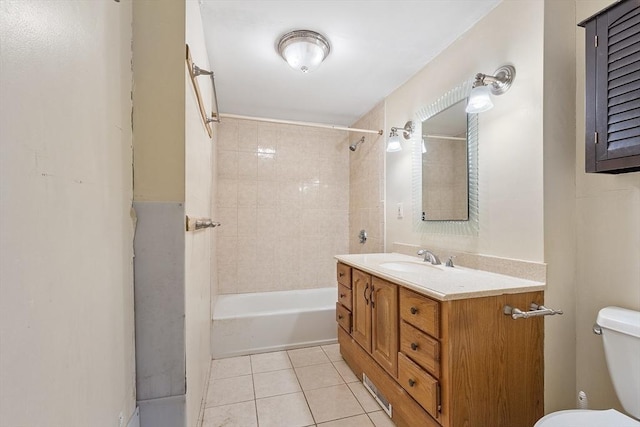 full bathroom with tile patterned flooring, vanity, tiled shower / bath combo, and toilet