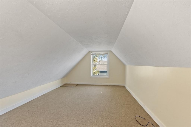 bonus room with lofted ceiling, carpet, and a textured ceiling