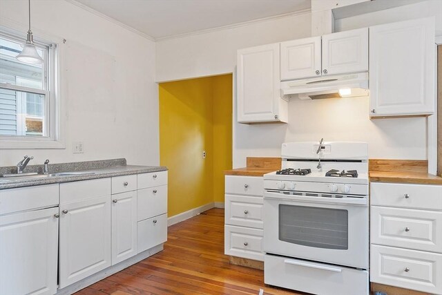 kitchen with sink, crown molding, gas range gas stove, hanging light fixtures, and white cabinets