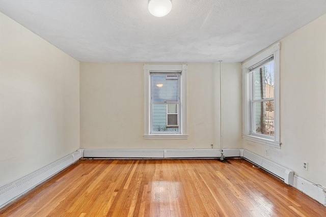 empty room with a baseboard radiator and light wood-type flooring