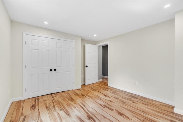 unfurnished bedroom featuring light hardwood / wood-style flooring and a closet