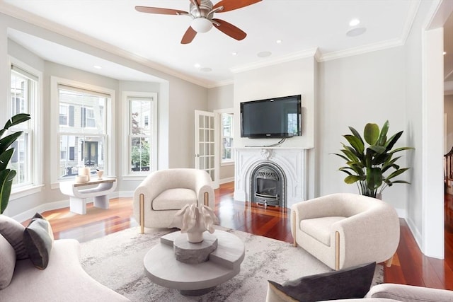 living room featuring ceiling fan, wood-type flooring, and crown molding