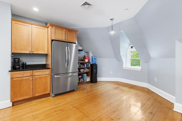 kitchen with freestanding refrigerator, baseboards, light wood-style floors, vaulted ceiling, and dark stone countertops