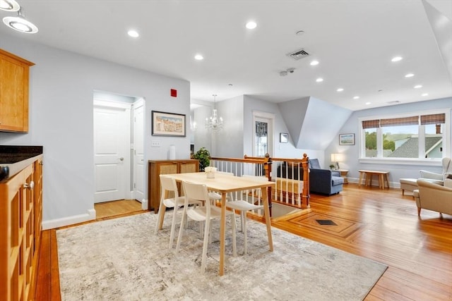 dining space with baseboards, light wood finished floors, recessed lighting, and a chandelier