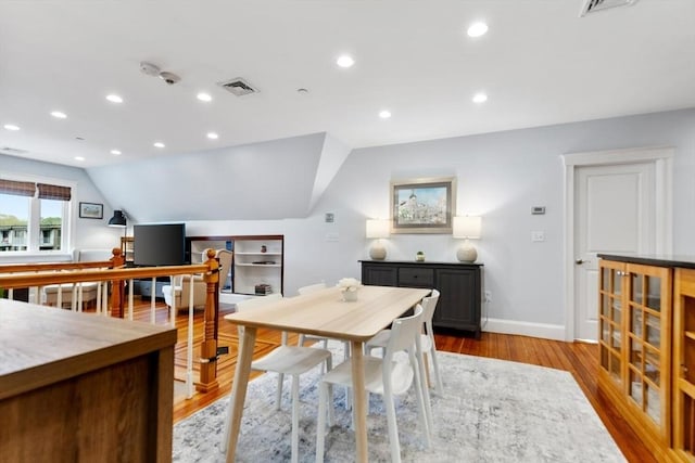 dining space with vaulted ceiling, light wood finished floors, baseboards, and recessed lighting