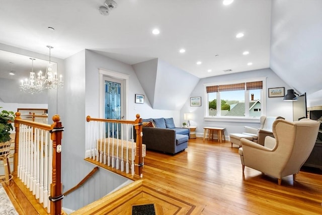 living area featuring an upstairs landing, lofted ceiling, light wood-style flooring, recessed lighting, and a chandelier