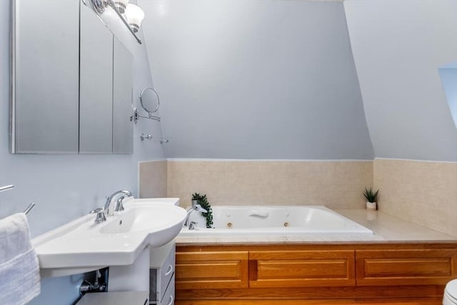 bathroom with a tub with jets and a sink