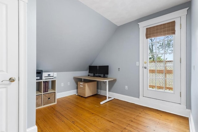 unfurnished office with light wood finished floors, vaulted ceiling, and baseboards