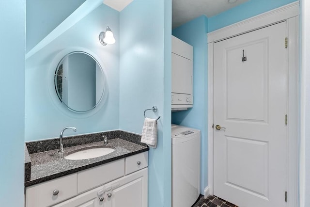 bathroom with stacked washing machine and dryer and vanity