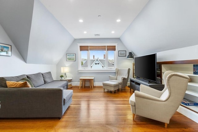 living room featuring wood finished floors, lofted ceiling, baseboards, and recessed lighting