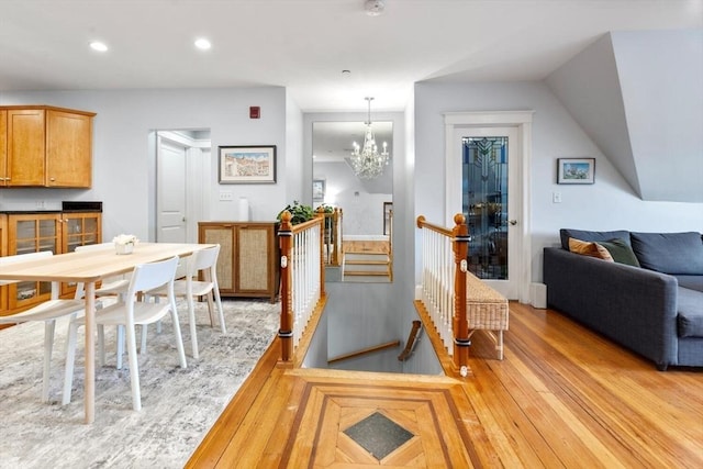 kitchen featuring light wood-style flooring, a chandelier, recessed lighting, pendant lighting, and open floor plan