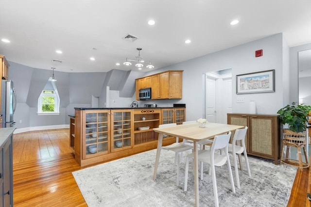 dining room with light wood-type flooring, recessed lighting, and baseboards
