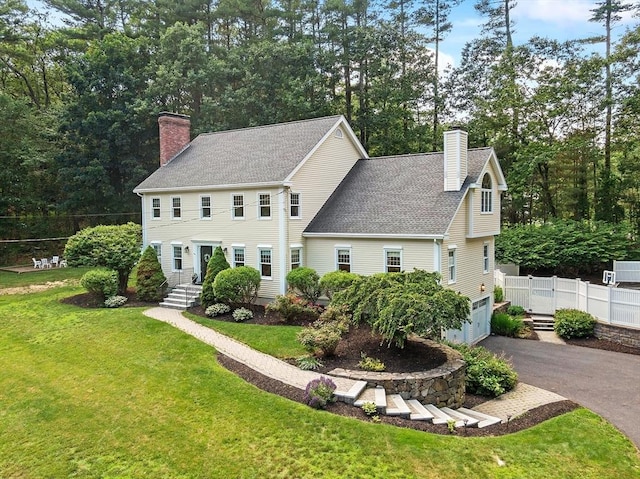 74 Charter Rd, Acton, MA 01720 - colonial-style house with a chimney, driveway, roof with shingles, and an attached garage