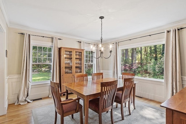 74 Charter Rd, Acton, MA 01720 - dining space with a chandelier, a decorative wall, light wood-style floors, ornamental molding, and wainscoting
