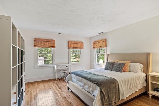 74 Charter Rd, Acton, MA 01720 - bedroom with multiple windows and wood-type flooring