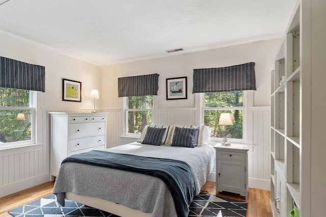 74 Charter Rd, Acton, MA 01720 - bedroom featuring a wainscoted wall, wood finished floors, and a decorative wall