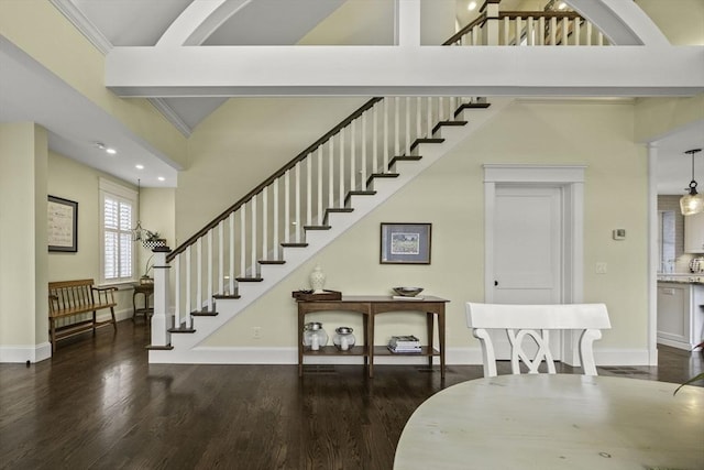 stairway with hardwood / wood-style flooring, crown molding, and a towering ceiling