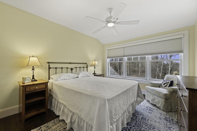 bedroom featuring multiple windows, vaulted ceiling, dark wood-type flooring, and ceiling fan