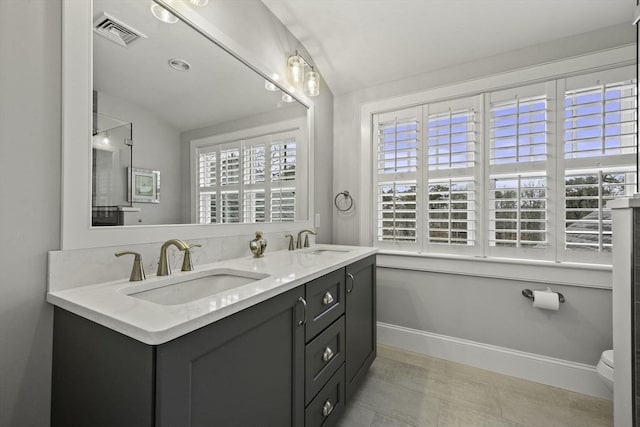 bathroom with plenty of natural light, toilet, and vanity