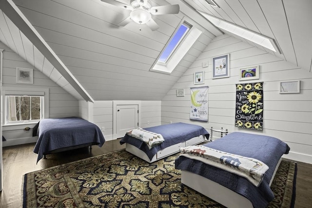 bedroom with ceiling fan, wooden walls, dark hardwood / wood-style flooring, and vaulted ceiling