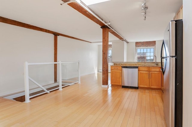 kitchen with stainless steel appliances, track lighting, light wood-style floors, baseboards, and open floor plan