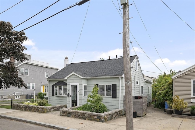 50 Triton Ave, Winthrop, MA 02152 - view of front of home featuring roof with shingles, a patio area, and a chimney