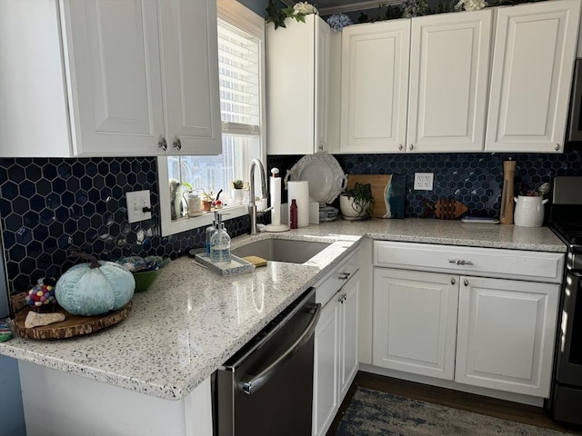 kitchen featuring stainless steel appliances, white cabinetry, and a sink