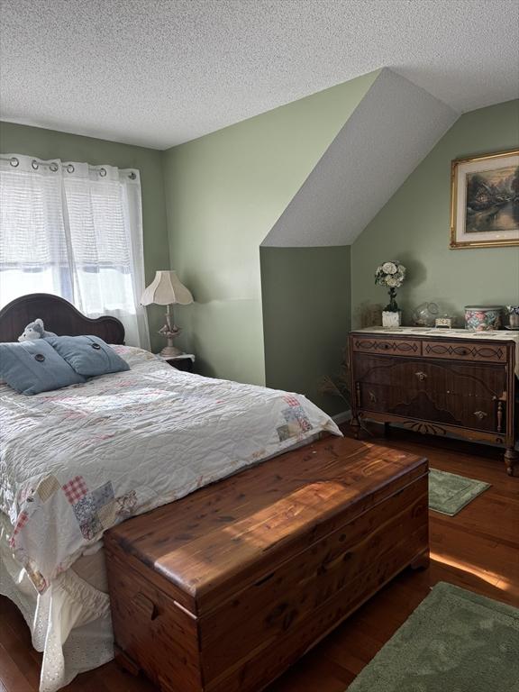 bedroom featuring dark wood-style flooring and a textured ceiling