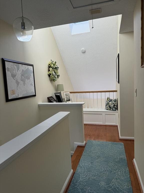 hallway featuring wood finished floors and a skylight