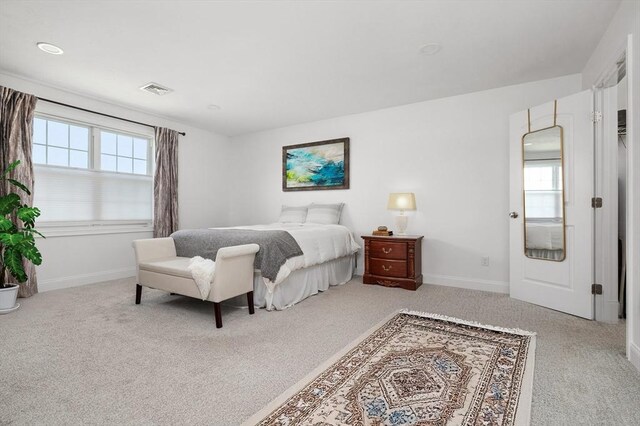 carpeted bedroom featuring baseboards and visible vents