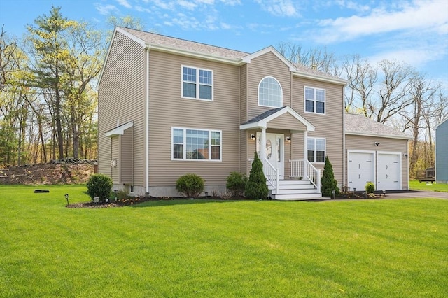 view of front facade with an attached garage, aphalt driveway, and a front yard