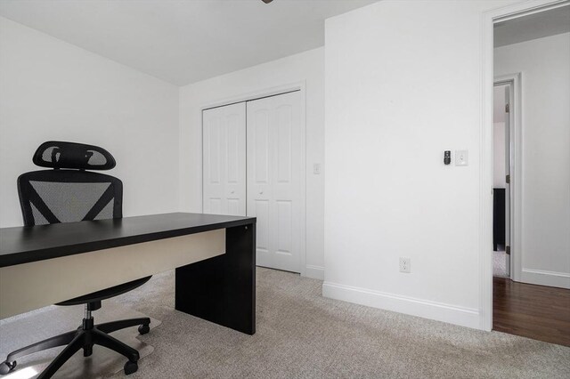 unfurnished office featuring baseboards and carpet