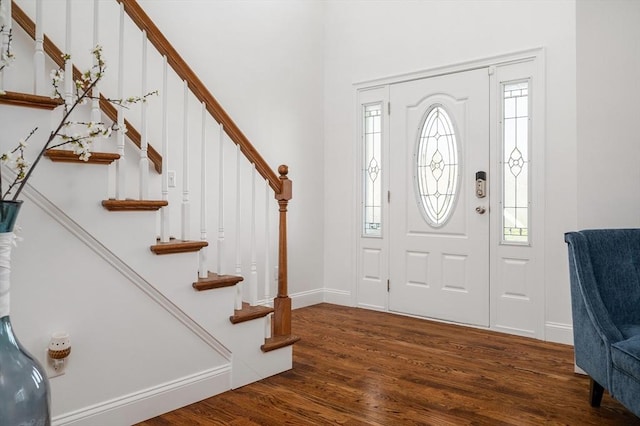 foyer featuring stairway, baseboards, and wood finished floors