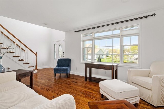 living area featuring baseboards, stairs, and wood finished floors