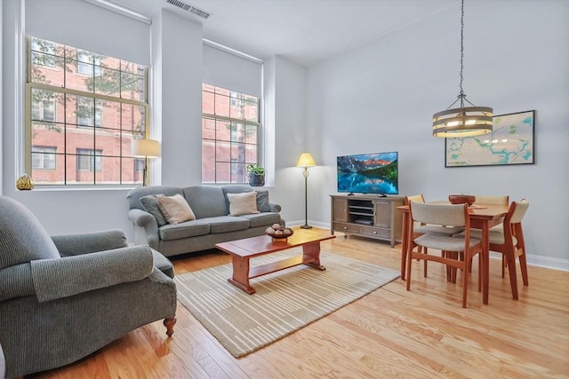 living room featuring an inviting chandelier and light hardwood / wood-style floors