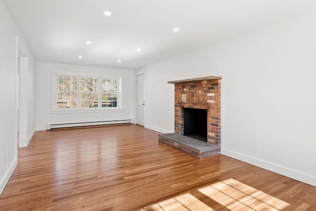 unfurnished living room with recessed lighting, a baseboard heating unit, wood finished floors, baseboards, and a brick fireplace