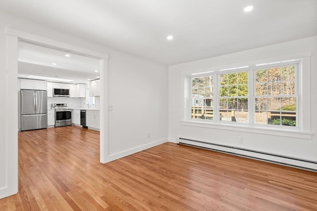 unfurnished living room featuring a baseboard radiator, baseboards, light wood-style flooring, and recessed lighting