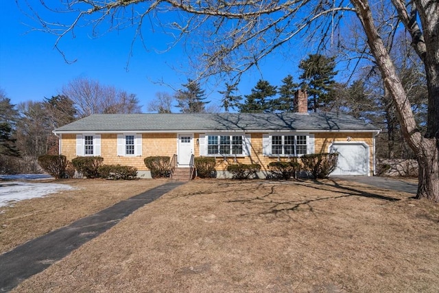 ranch-style house with aphalt driveway, a chimney, an attached garage, entry steps, and a front yard