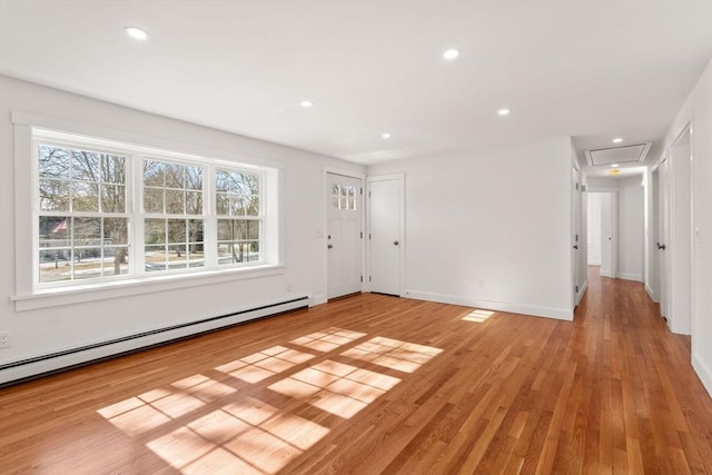 interior space featuring light wood-style flooring, a baseboard heating unit, baseboards, and recessed lighting